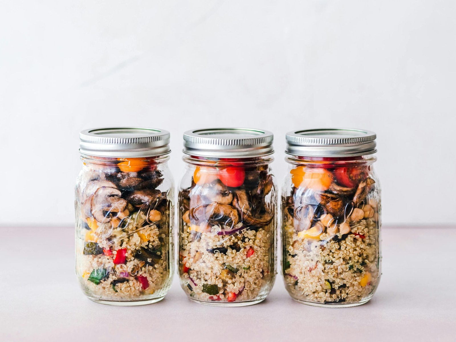 Colorful quinoa salad jar with roasted veggies, ideal for healthy meal prep.